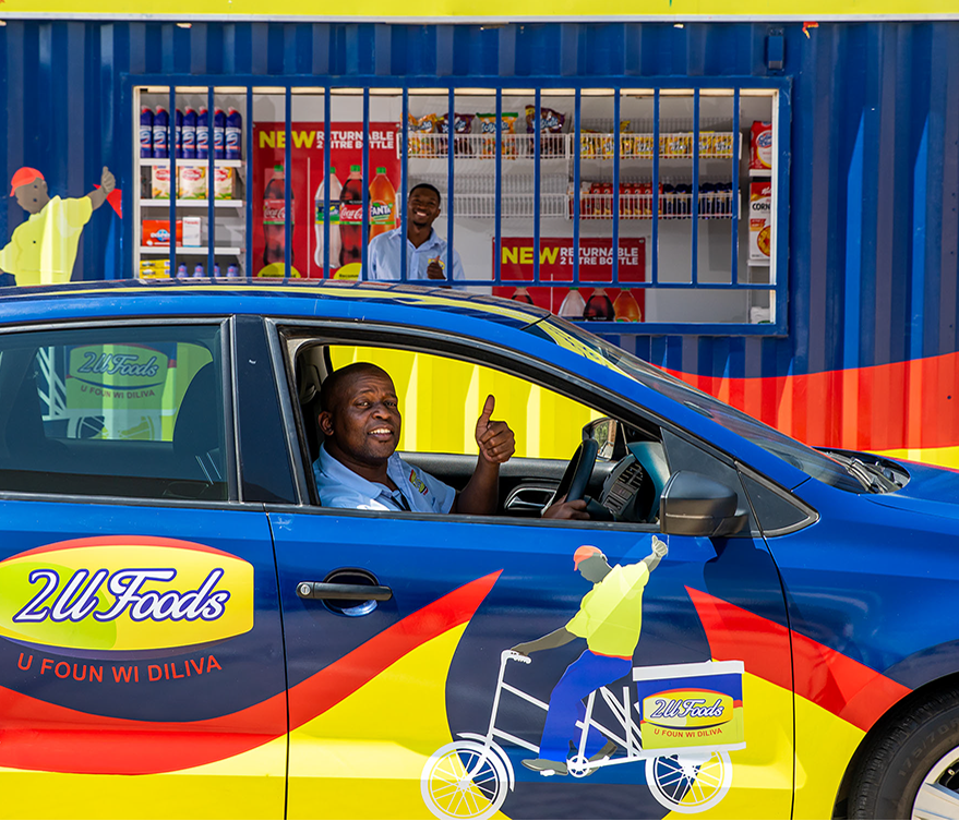 2U Foods staff and a branded vehicle outside a community store
