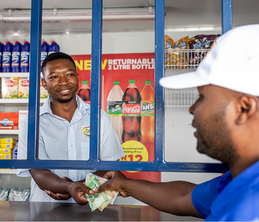 A 2U Foods retailer serving a customer at the store counter